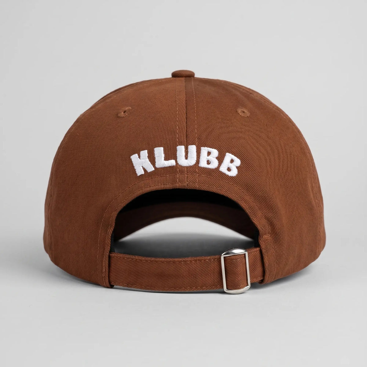 Casquette Klubb marron vue de dos, KLUBB brodé blanc en arc et sangle ajustable à boucle métal argentée