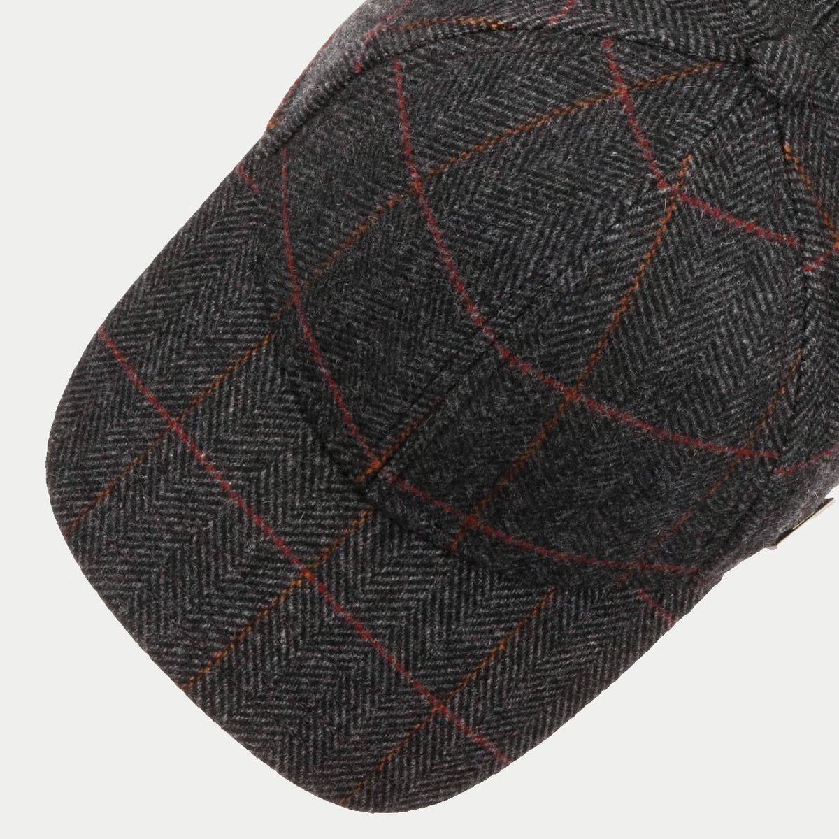Visière et calotte de la casquette Kinty grise vues de dessus, chevrons et carreaux rouges et orange