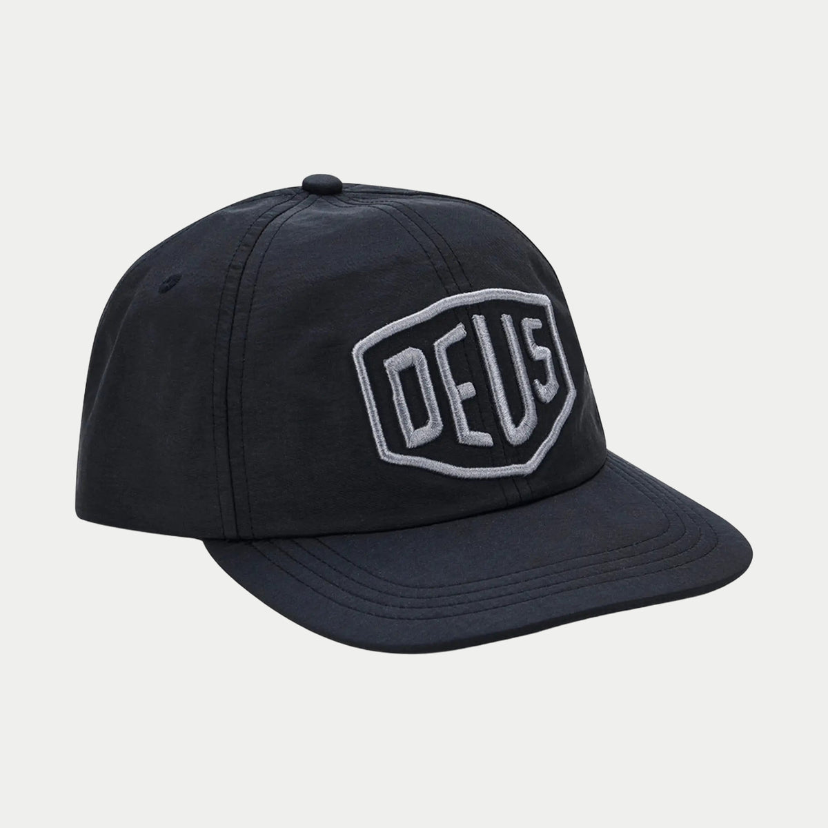 Casquette 5 panneaux en nylon noir, gros bouclier Deus brodé en relief gris sur la façade