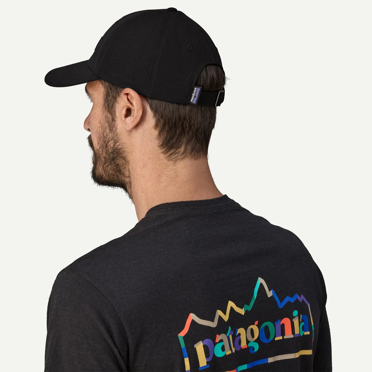 Casquette P-6 Label Trad noire Patagonia portée de dos, attache réglable en tissu et étiquette patagonia