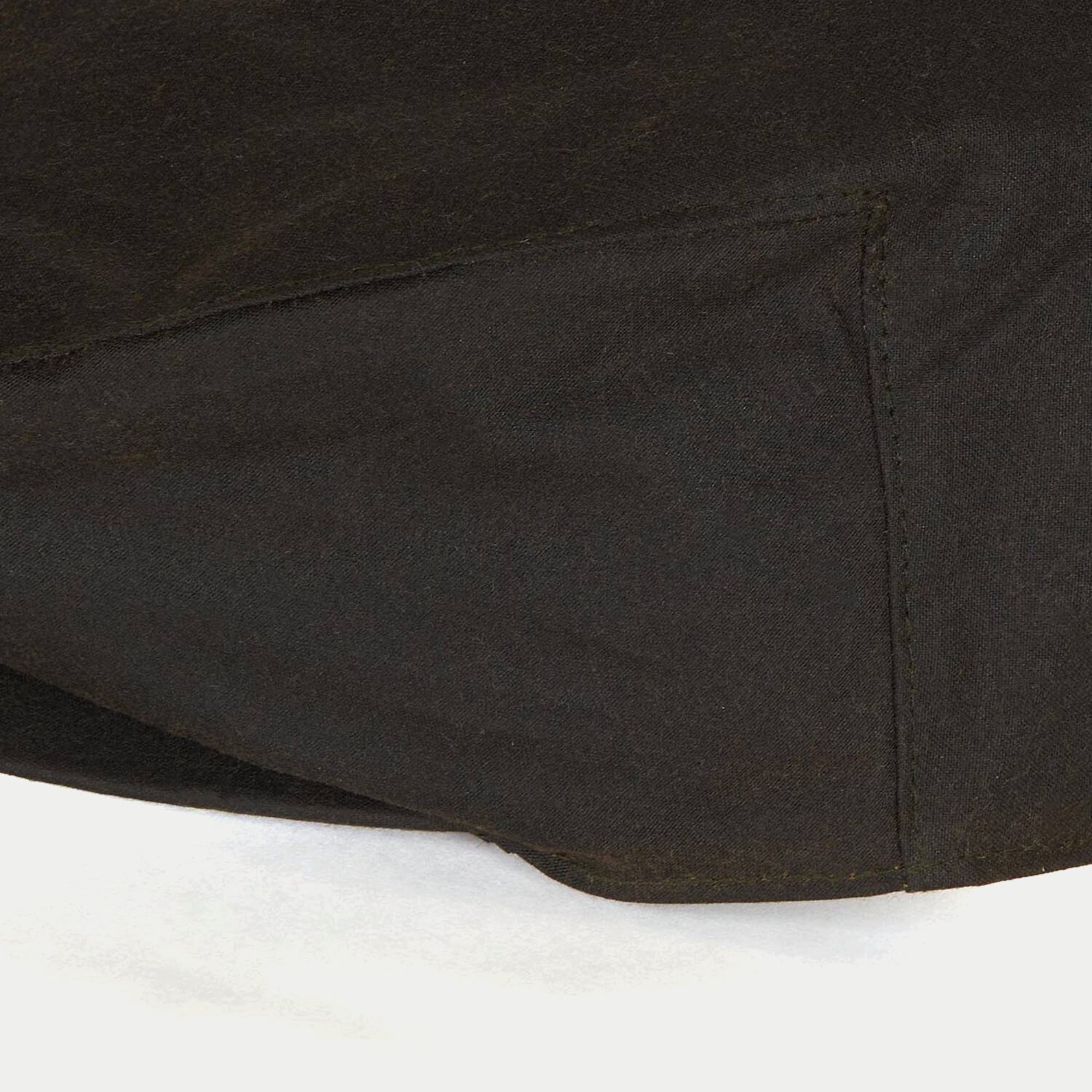 Casquette plate cirée olive Barbour - gros plan sur les coutures de la calotte en coton ciré