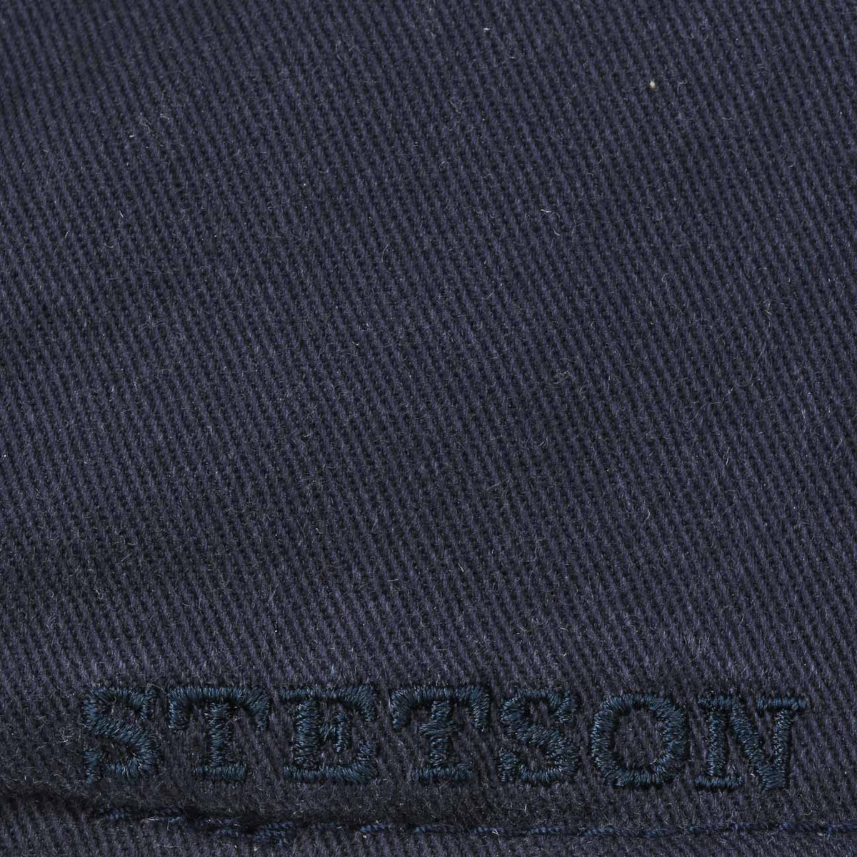 Gros plan de la broderie Stetson ton sur ton sur le côté bleu marine