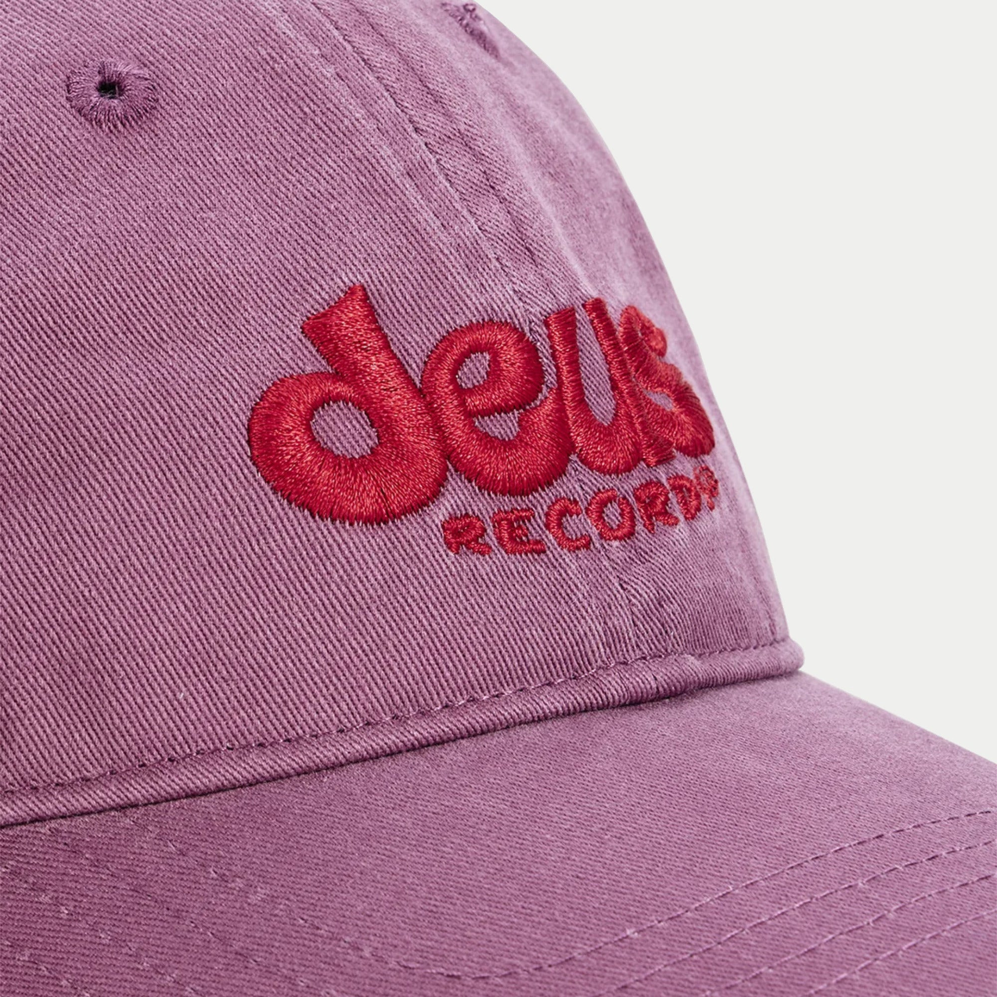 Casquette Smile mauve Deus Ex Machina - macro de la broderie deus Records rouge en relief sur le sergé de coton délavé