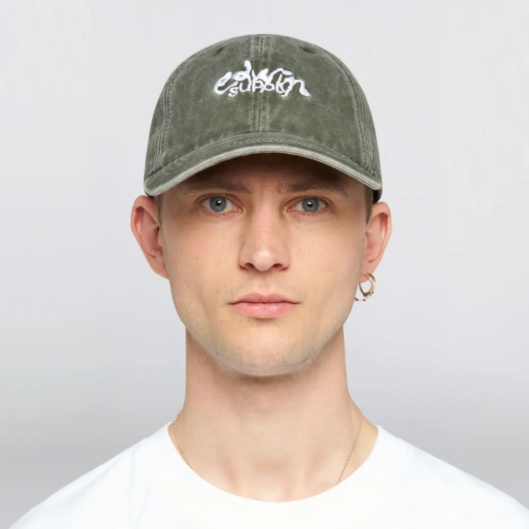 Casquette Soft Washed vert olive portée de face, broderie blanche edwin supply sur le panneau avant