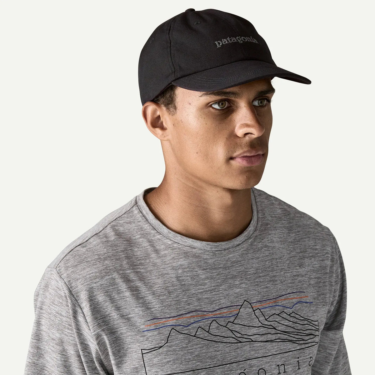 Casquette Text Logo noire portée de trois-quarts, calotte souple et visière préformée