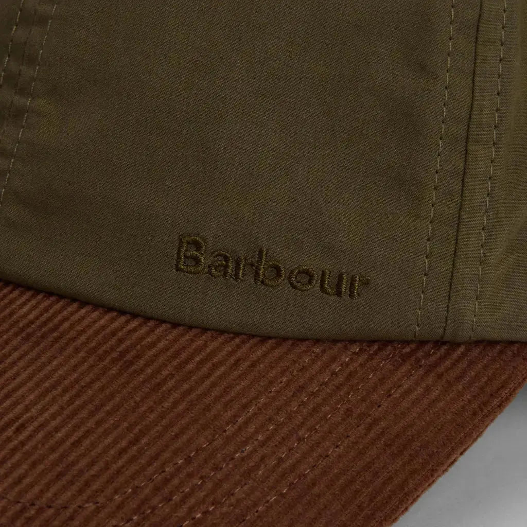 Macro du logo brodé ton sur ton olive juste au-dessus du velours côtelé rouille