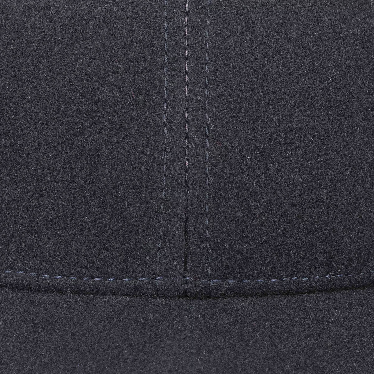 Gros plan sur les surpiqûres gris clair des pans de la casquette Vaby bleu marine