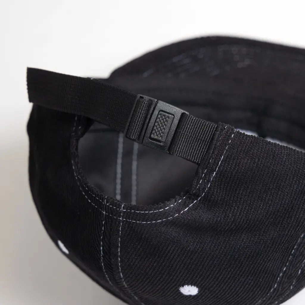 Arrière de la casquette noire : sangle en sergé et boucle plastique de serrage