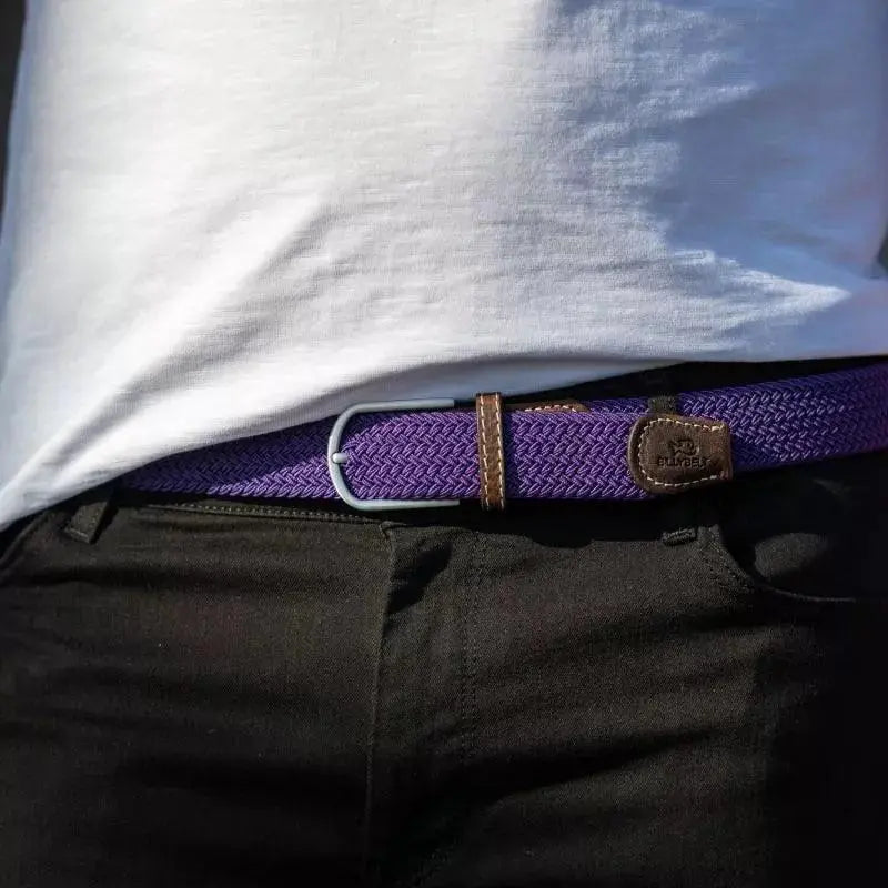 Tresse Astral violet bleuté portée sur un pantalon noir, boucle argentée, passant et patte de cuir brun visibles
