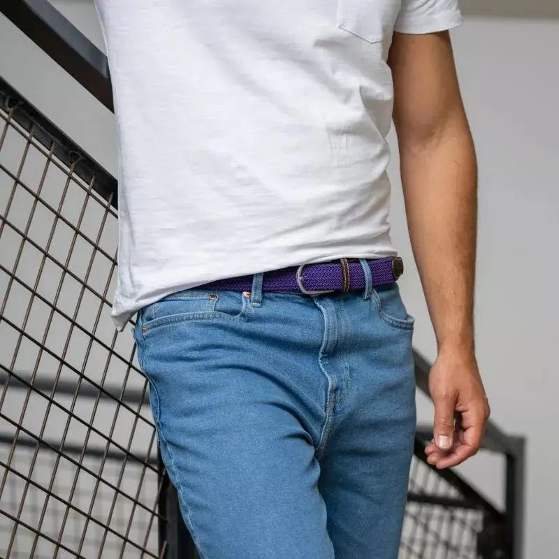 Ceinture violet indigo Astral à la taille d'un jean clair, cadrage large devant un escalier métallique