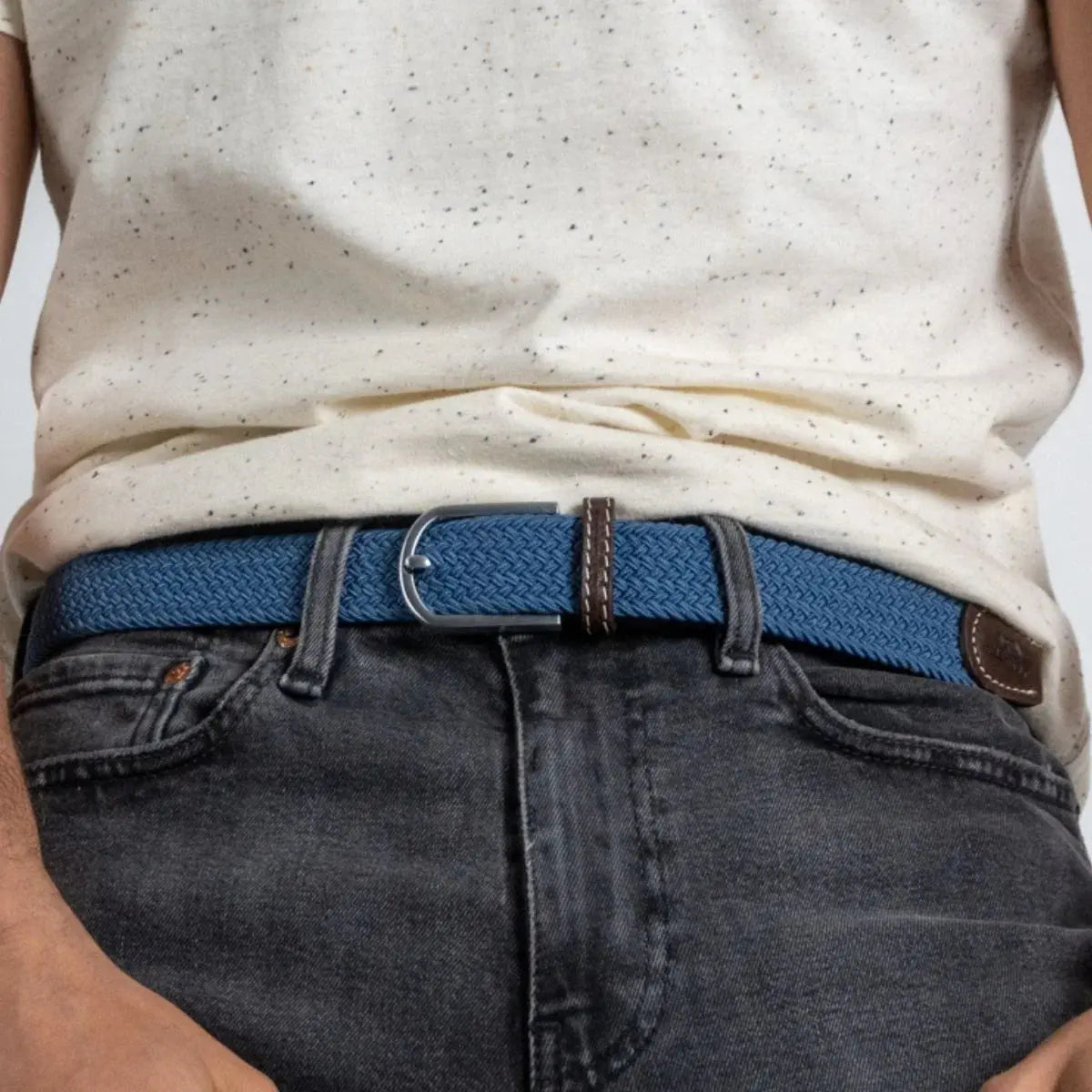Tresse bleu jean Bleu Air Force bouclée sur un denim gris foncé, boucle argent brossé sous un haut écru moucheté