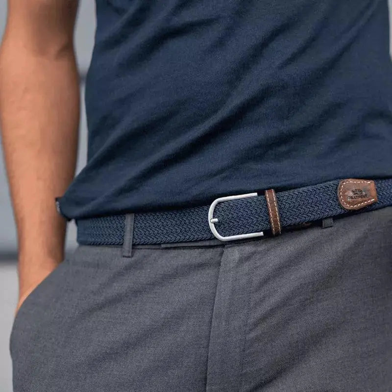 Tresse bleu ardoise portée sur un pantalon gris chiné, boucle argentée, passant de cuir brun et patte gravée