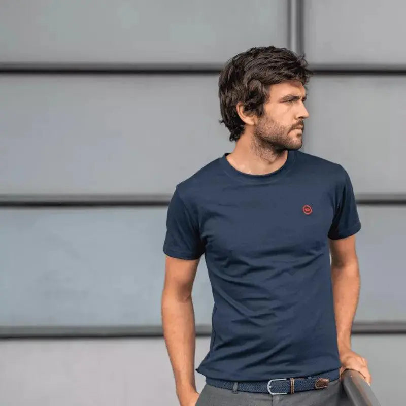 Cadrage large sur fond gris : la tresse Bleu Ardoise n'apparaît qu'en bas d'image, fermée sur un pantalon gris