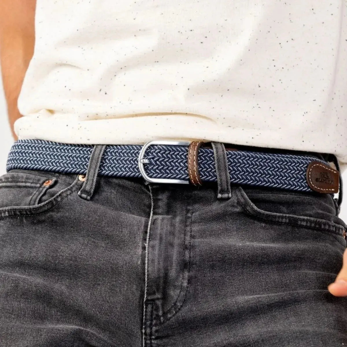 Tressage Bogota bleu marine et blanc porté sur un jean gris délavé, boucle argent brossé et passant de cuir brun