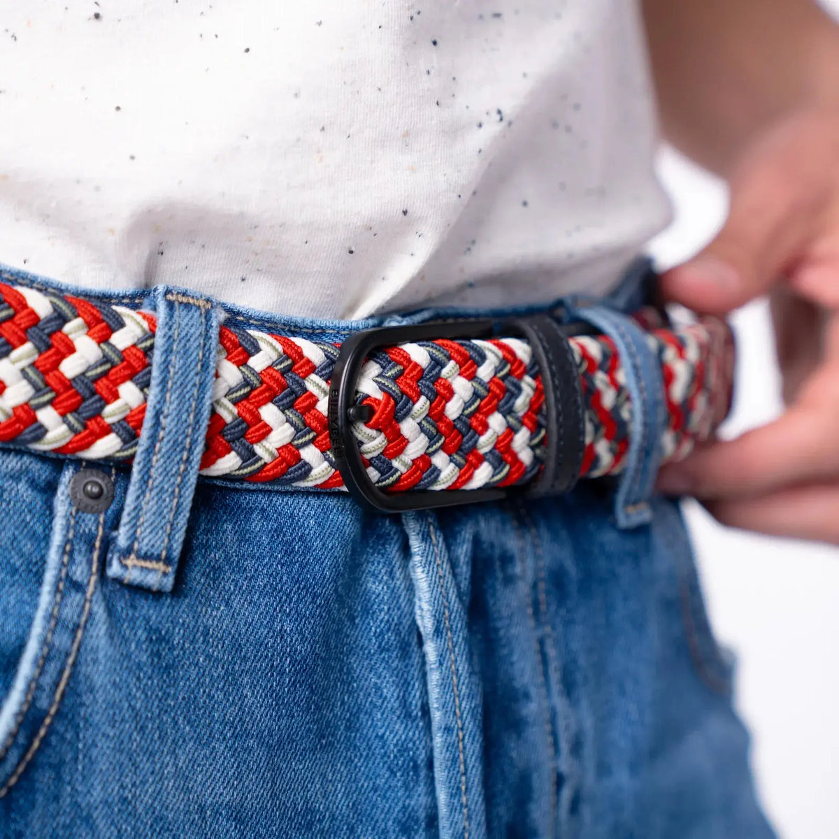 Gros plan : boucle noire mate refermée sur les chevrons rouge vif, écru et bleu gris de la ceinture Edmonton