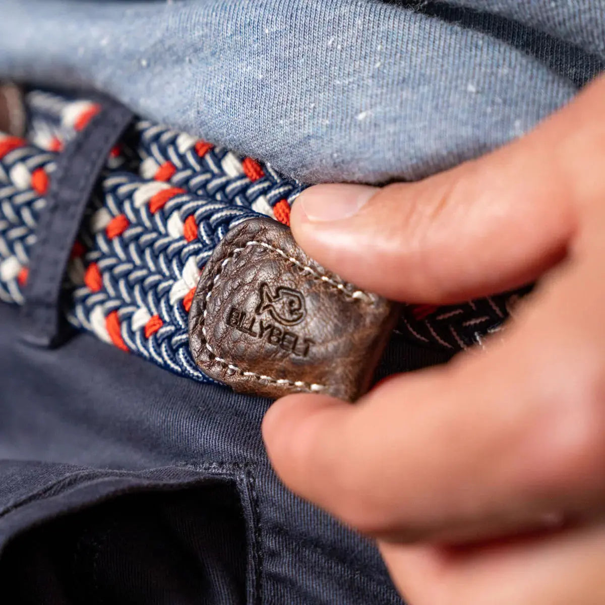 Patte de cuir brun surpiquée écru au poisson gravé, au bout de la tresse Frenchie marine, écru et orange