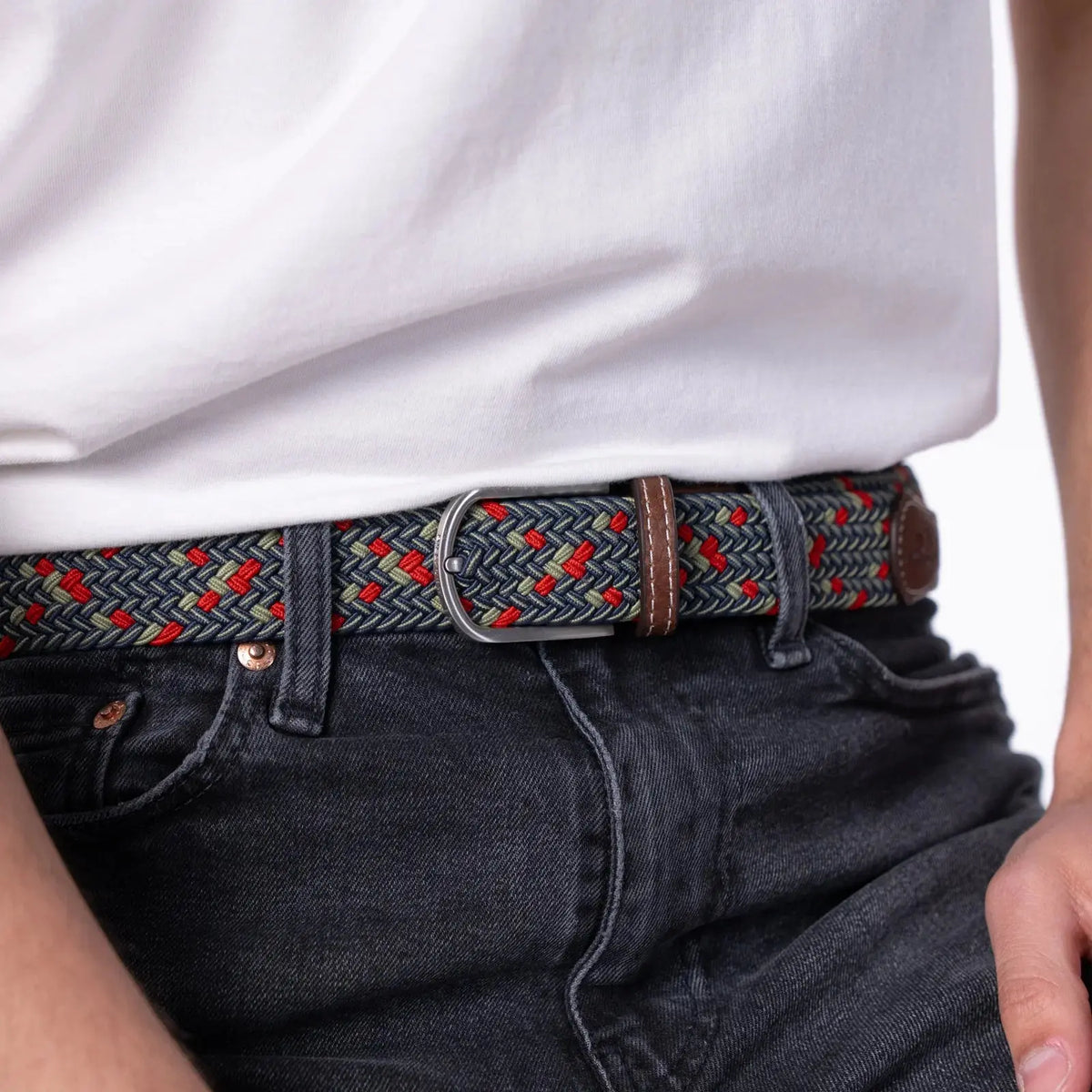 Ceinture Goteborg bleu marine, amande et rouge portée sur un jean noir, boucle argentée brossée et passant marron