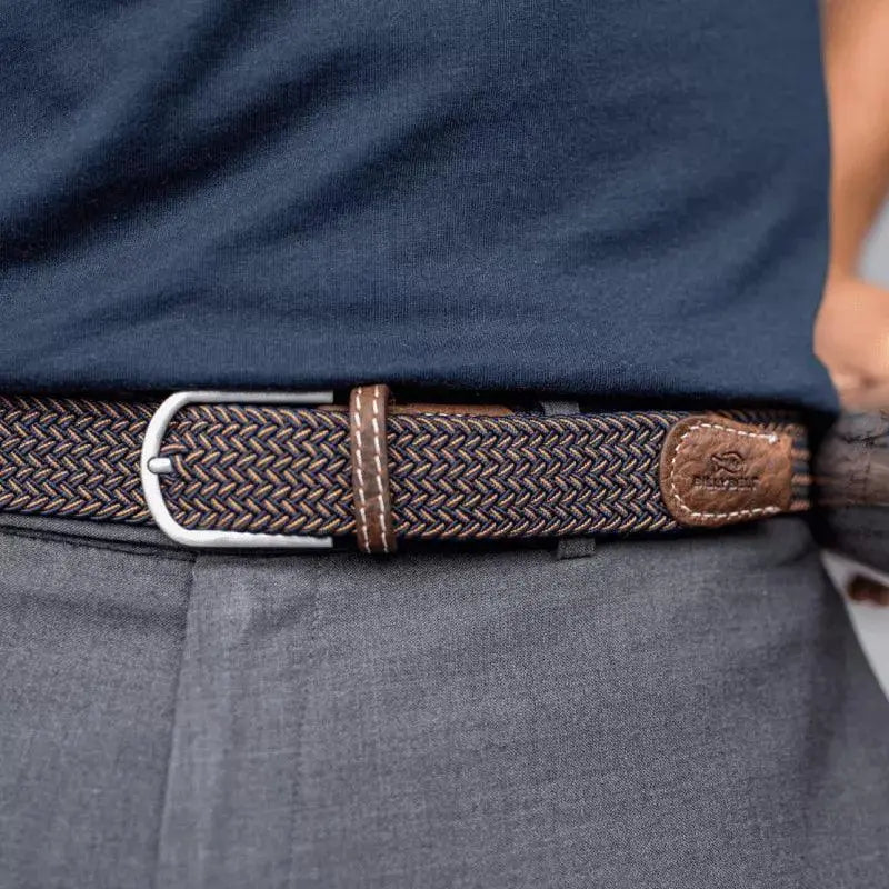 Ceinture Havane bleu marine et doré portée sur un pantalon gris, boucle argentée brossée et passant de cuir marron
