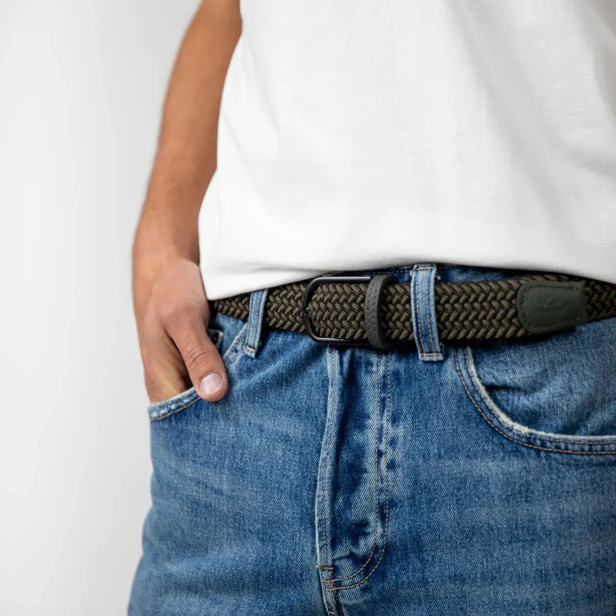 Ceinture Sherwood kaki foncé portée sur un jean bleu, boucle noire mate et tressage serré bien visible