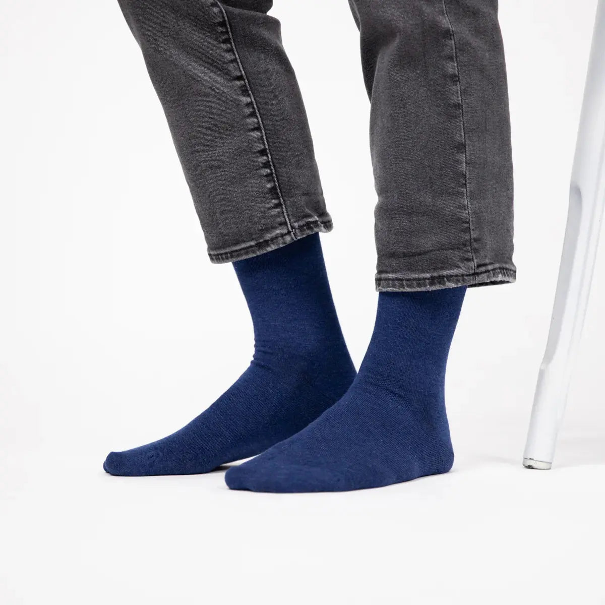 Chaussettes bleu chiné portées debout sous un jean gris, la maille laisse voir son grain de fils plus clairs
