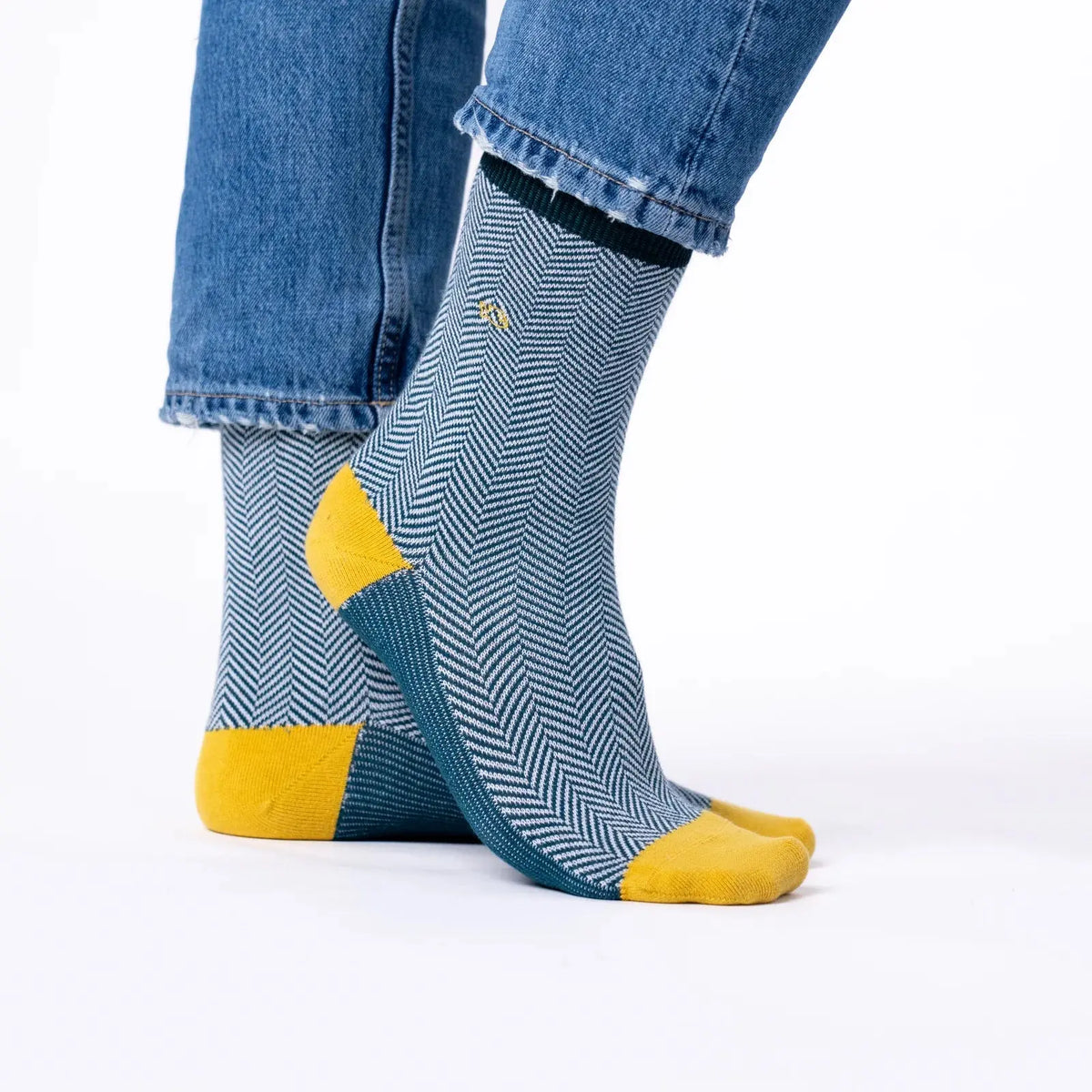 Chaussettes à chevrons bleu canard portées sous un jean, talon jaune moutarde et dessous de pied canard