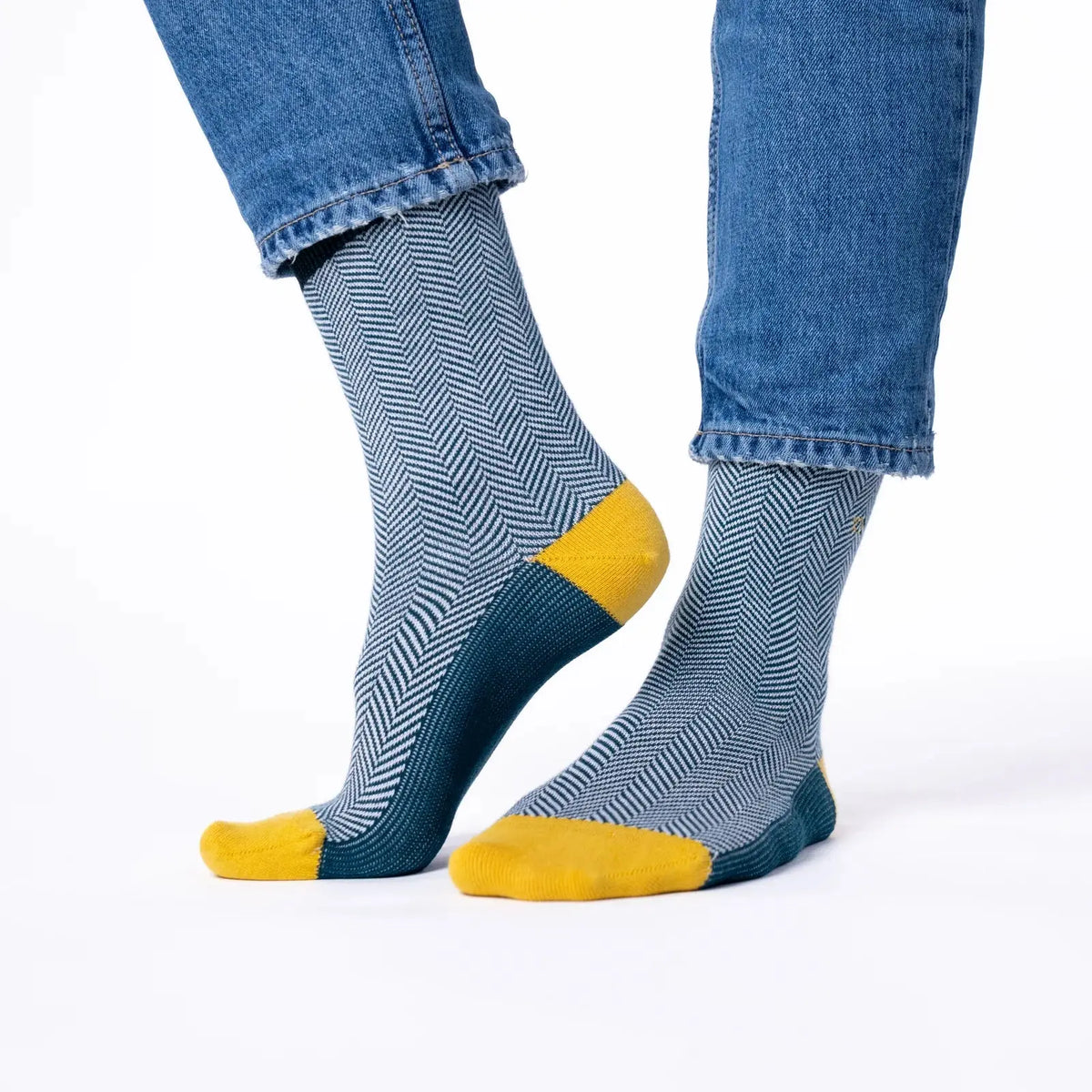 Paire à chevrons canard et blanc portée de trois quarts, pointes jaune moutarde et dessous du pied bleu canard