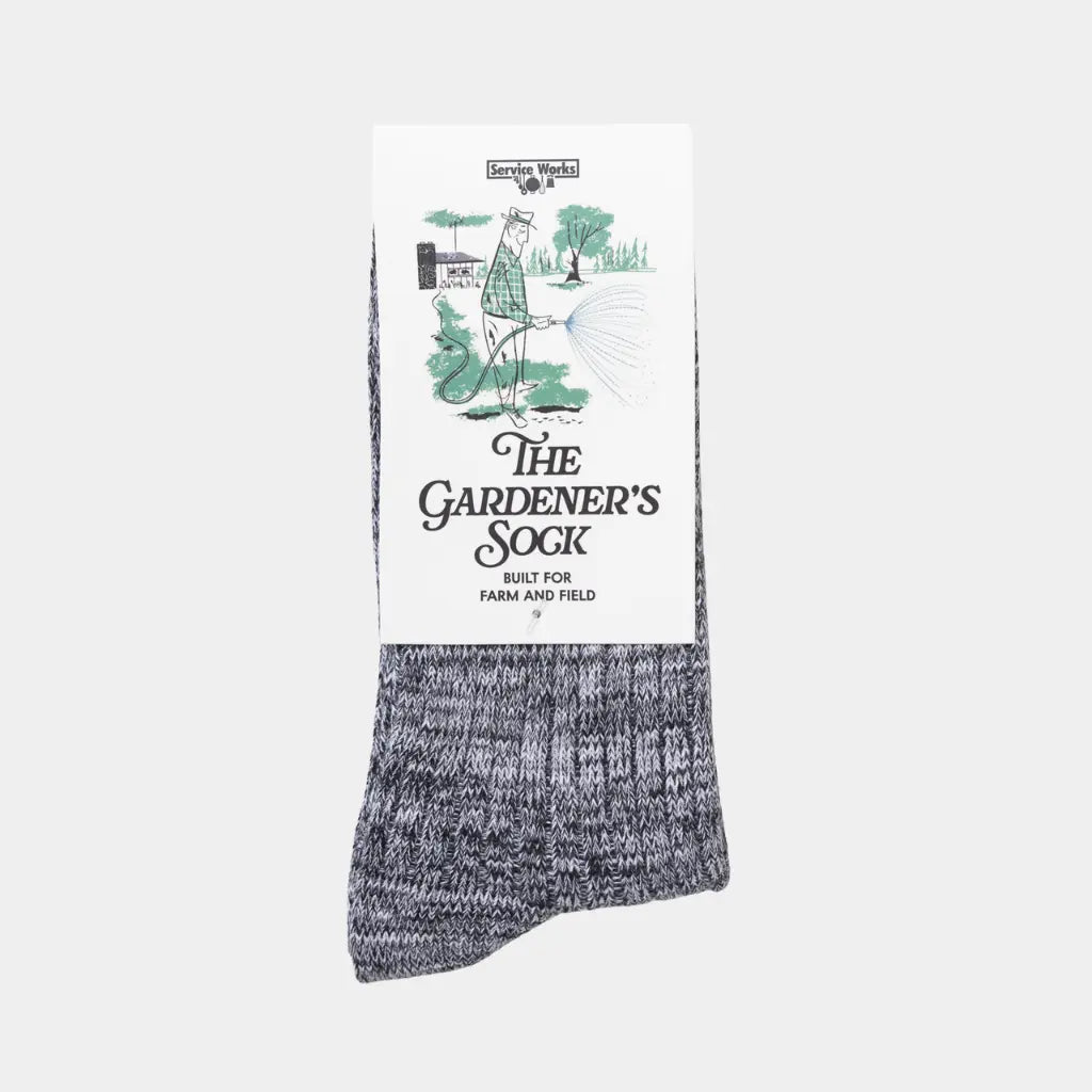 Chaussettes du Jardinier en maille chinée noir et blanc, sous leur carton illustré The Gardener's Sock