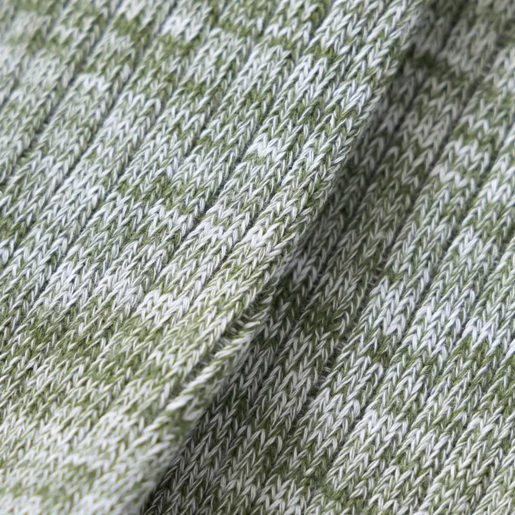 Macro du tricot chiné vert olive et blanc cassé, torsades de fils bien visibles
