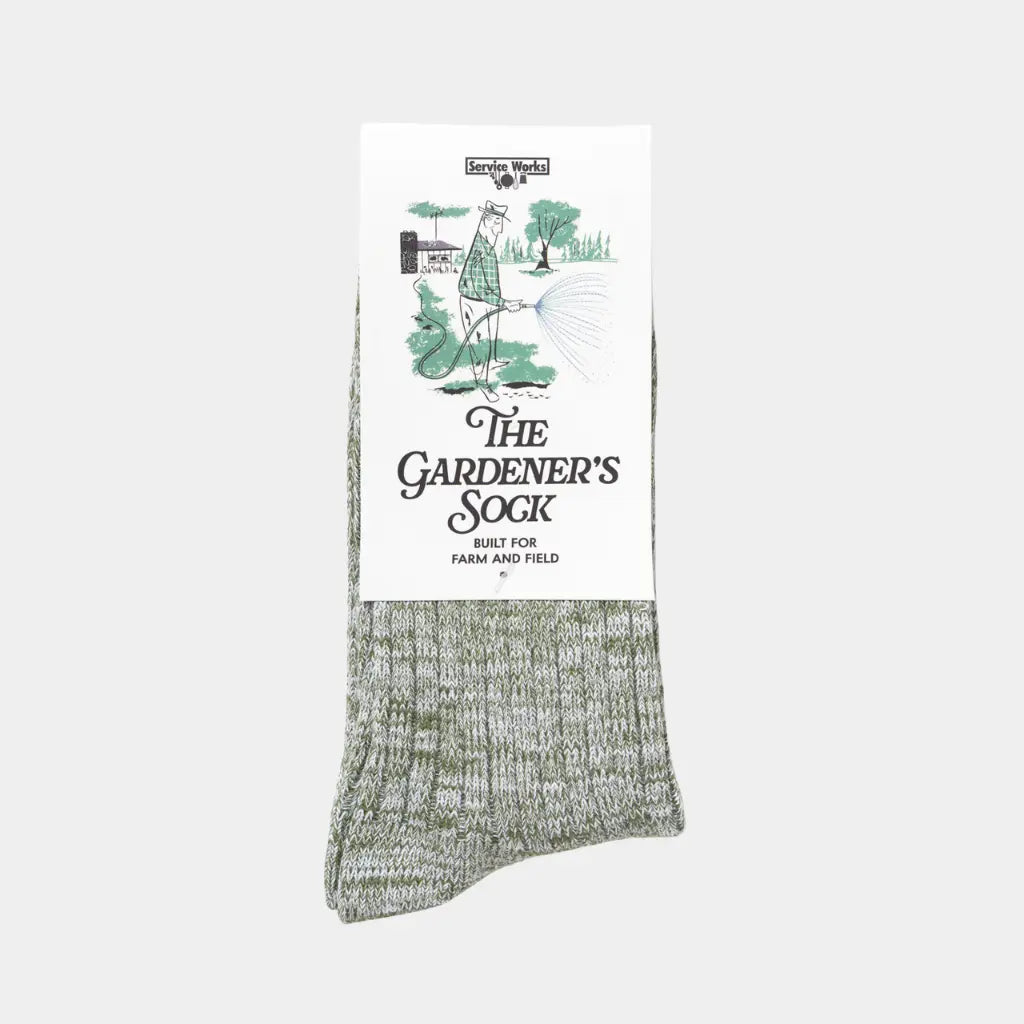 Chaussette du Jardinier vert kaki chiné, glissée dans son carton illustré The Gardener's Sock