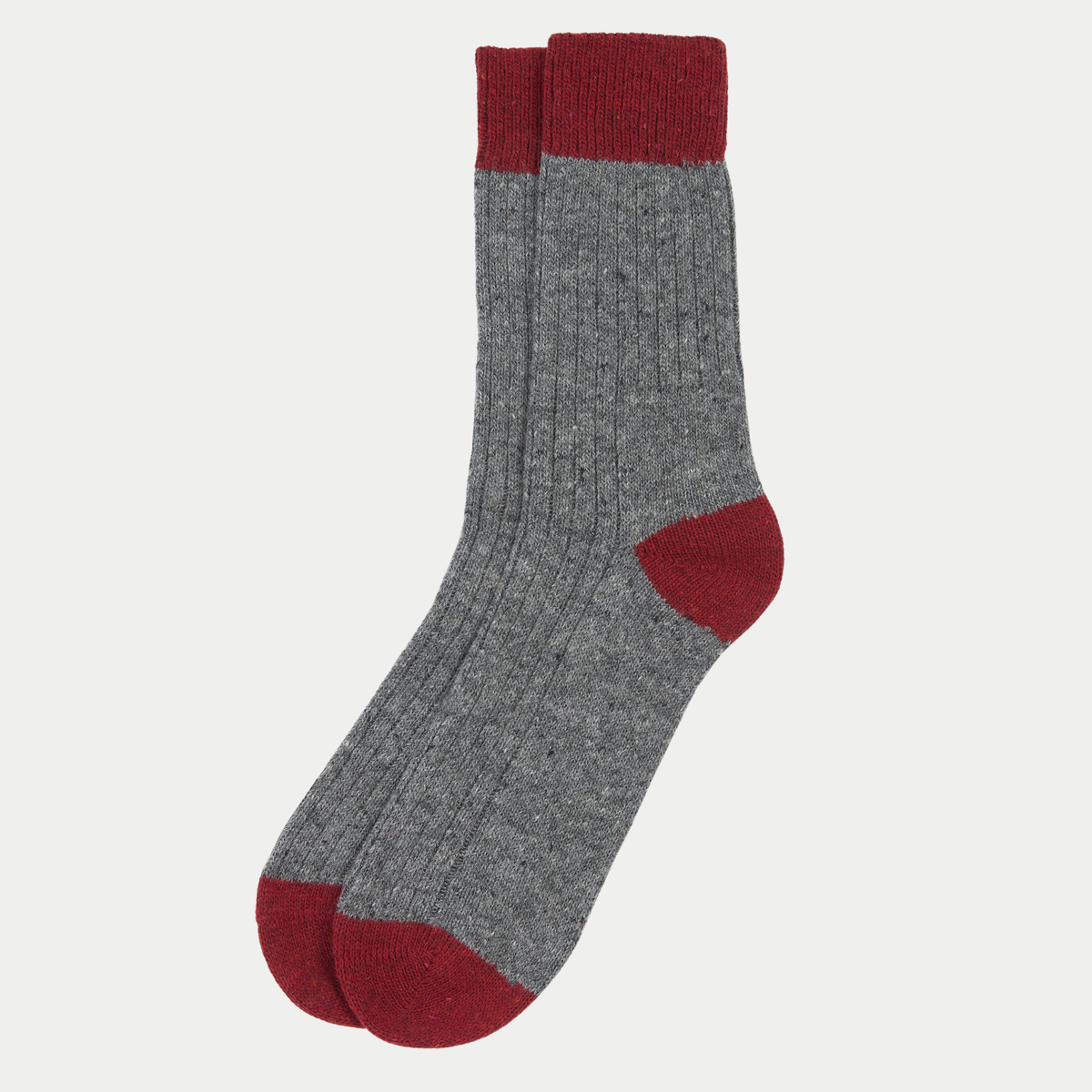 Les deux chaussettes Houghton posées à plat, laine gris chiné côtelée, bord-côte, talon et pointe rouge sombre.