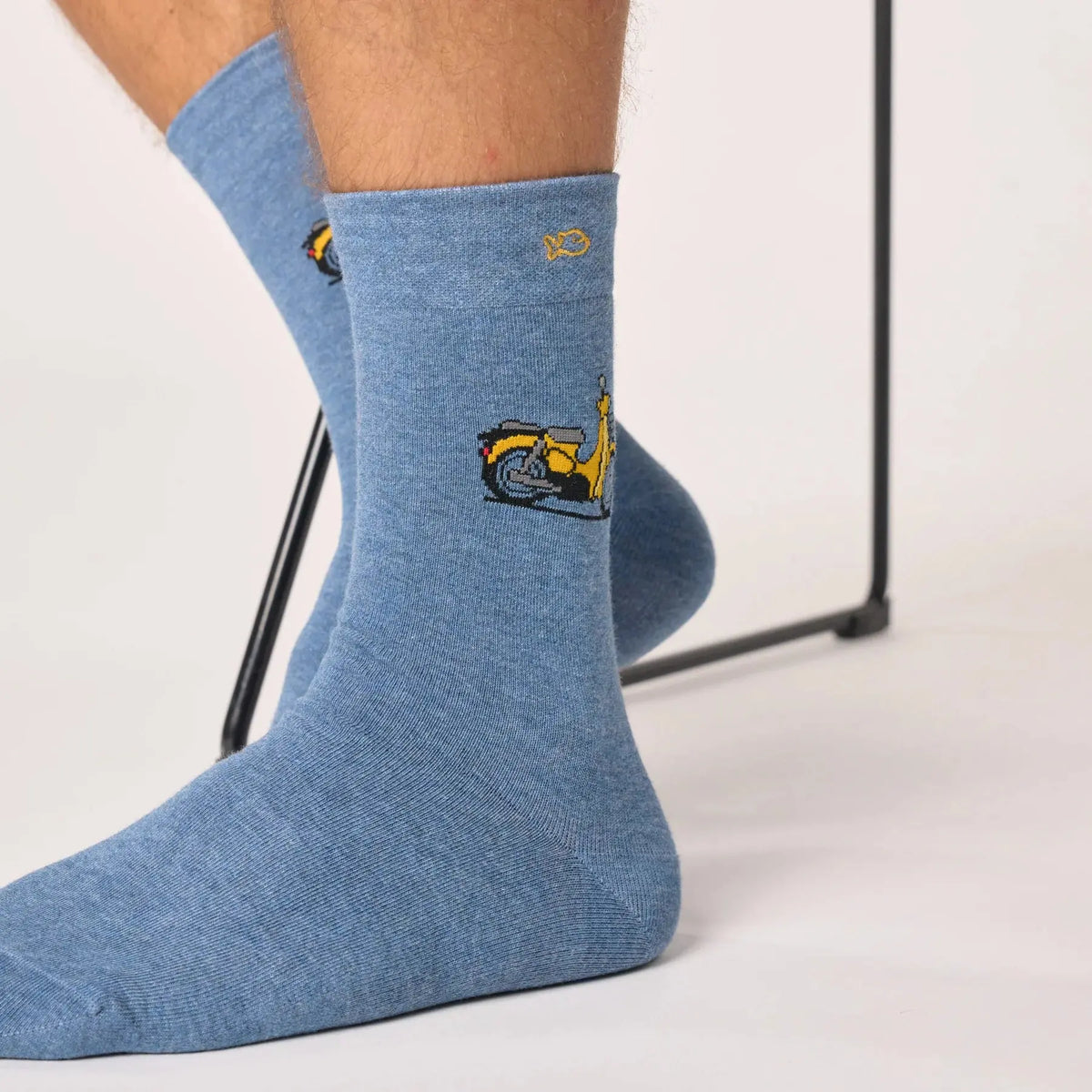 Chaussette bleu chiné vue de profil, le scooter jaune et son top-case gris tissés sur le côté de la tige