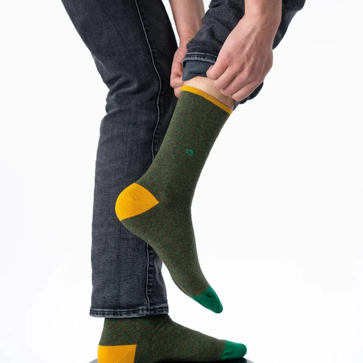 Chaussette kaki à micro-carrés vert sapin portée de profil, talon moutarde et pointe vert émeraude.