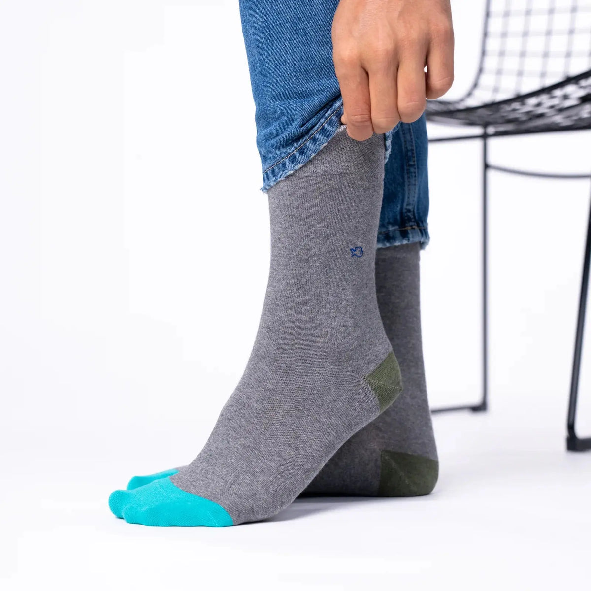 Chaussettes gris chiné portées sous un jean brut, pointe turquoise et talon kaki visibles