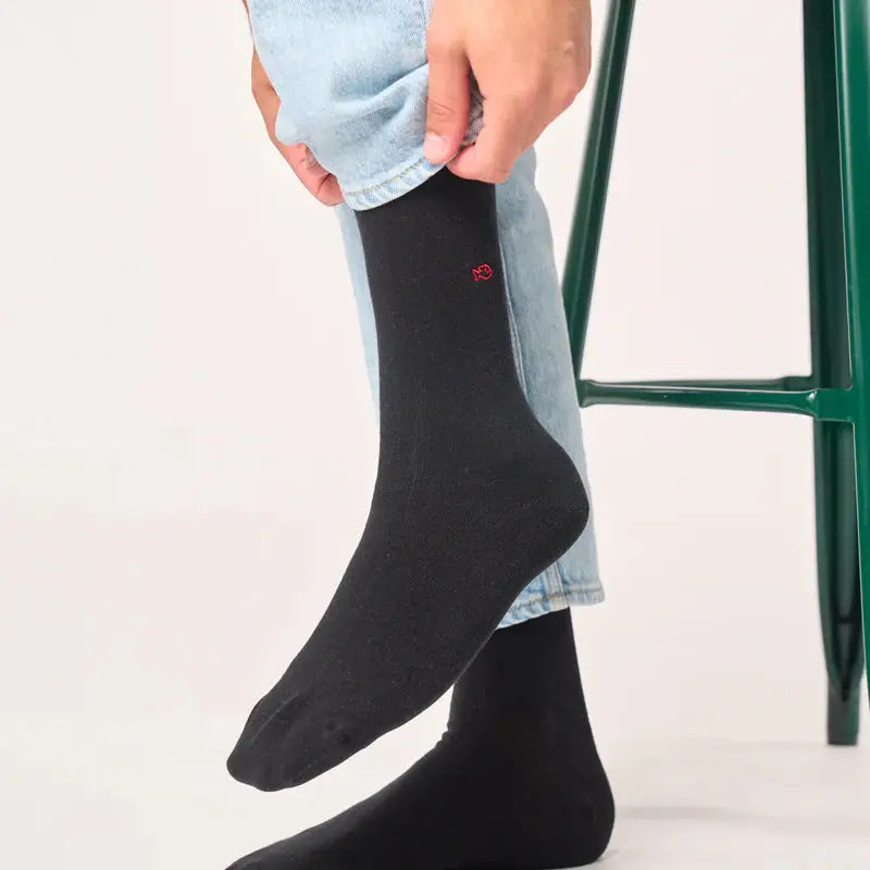 Chaussettes noires portées avec un jean clair, la tige mi-mollet remonte bien au-dessus de la cheville