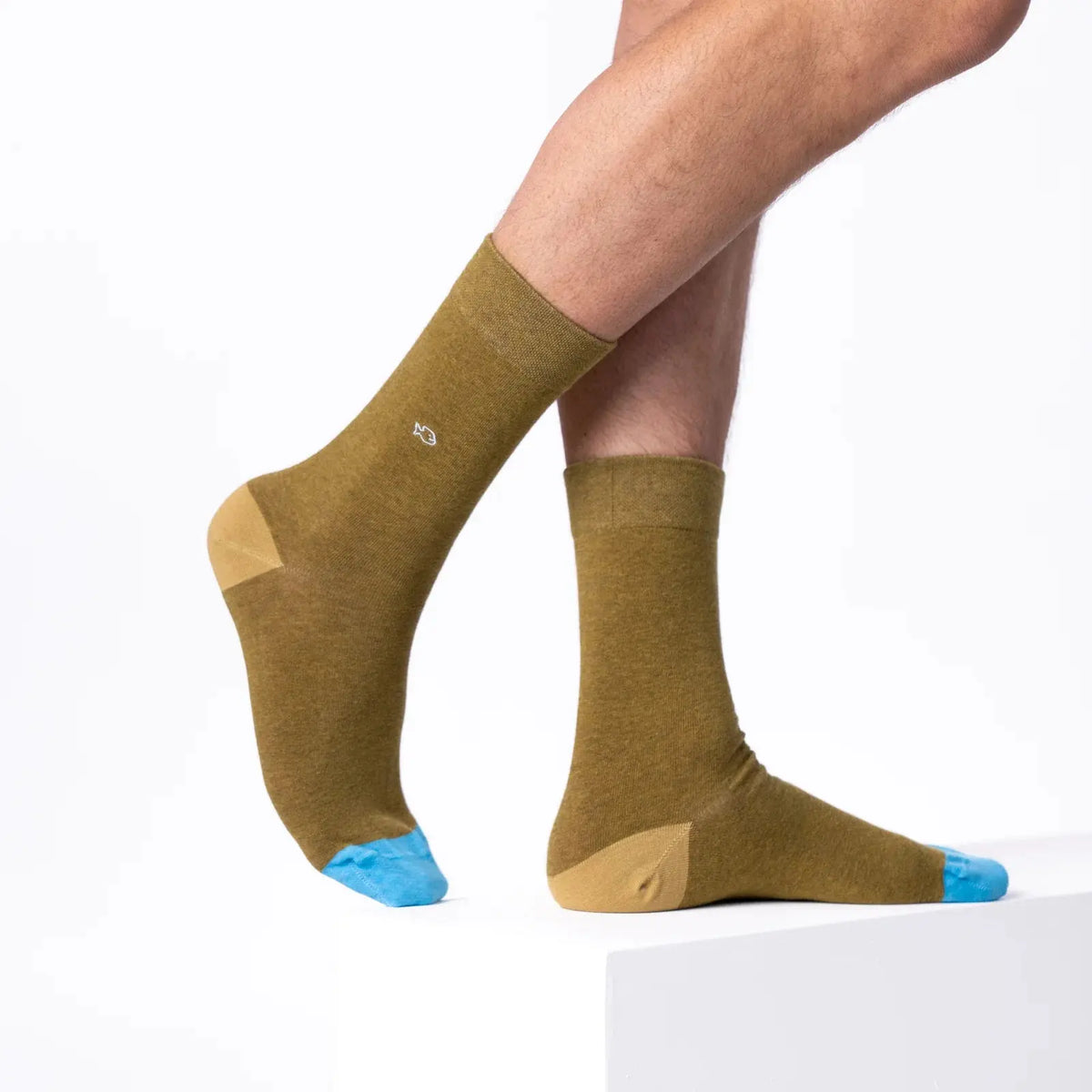 Chaussettes vert olive portées de profil, talon sable et pointe bleu ciel en contraste