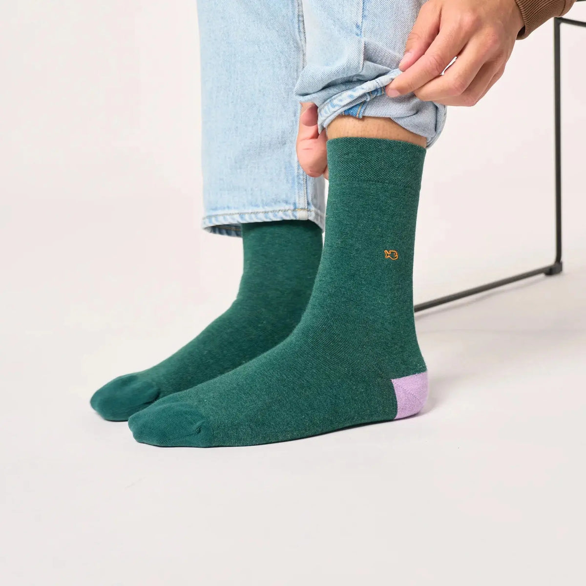 Chaussettes vert chiné portées sous un jean clair, talon lilas et broderie poisson orange