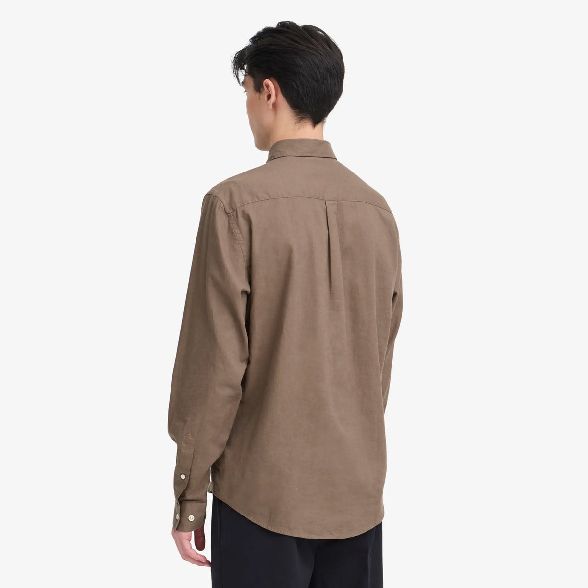 Vue de dos portée de la chemise marron, épaules aisées et poignets boutonnés