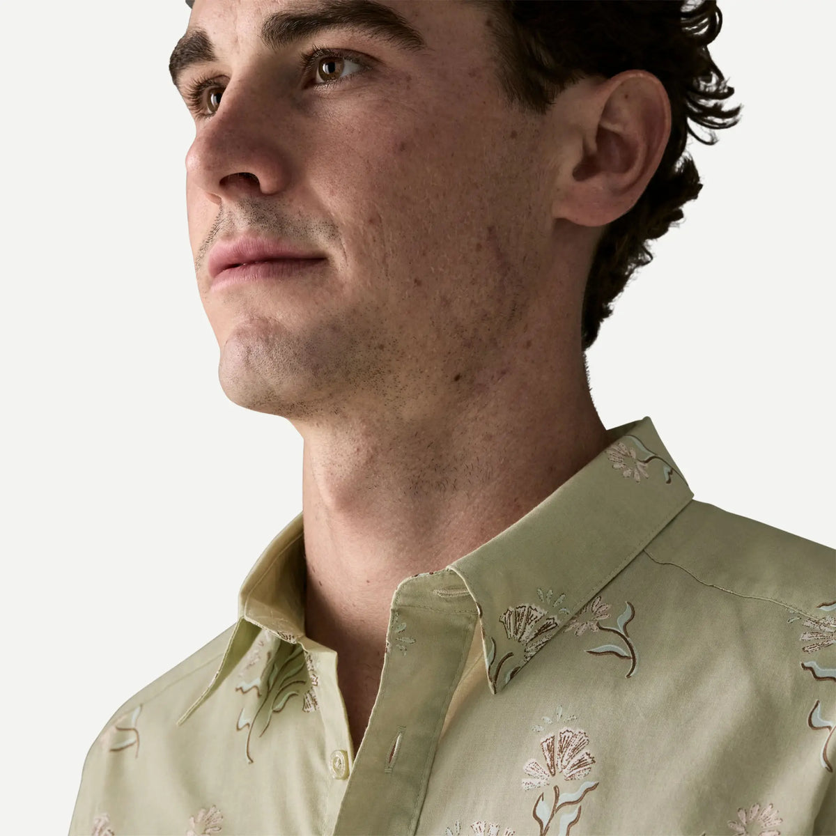 Gros plan du col chemise ouvert de la Go To Ocean Blooms Patagonia, imprimé écru sur fond vert sauge