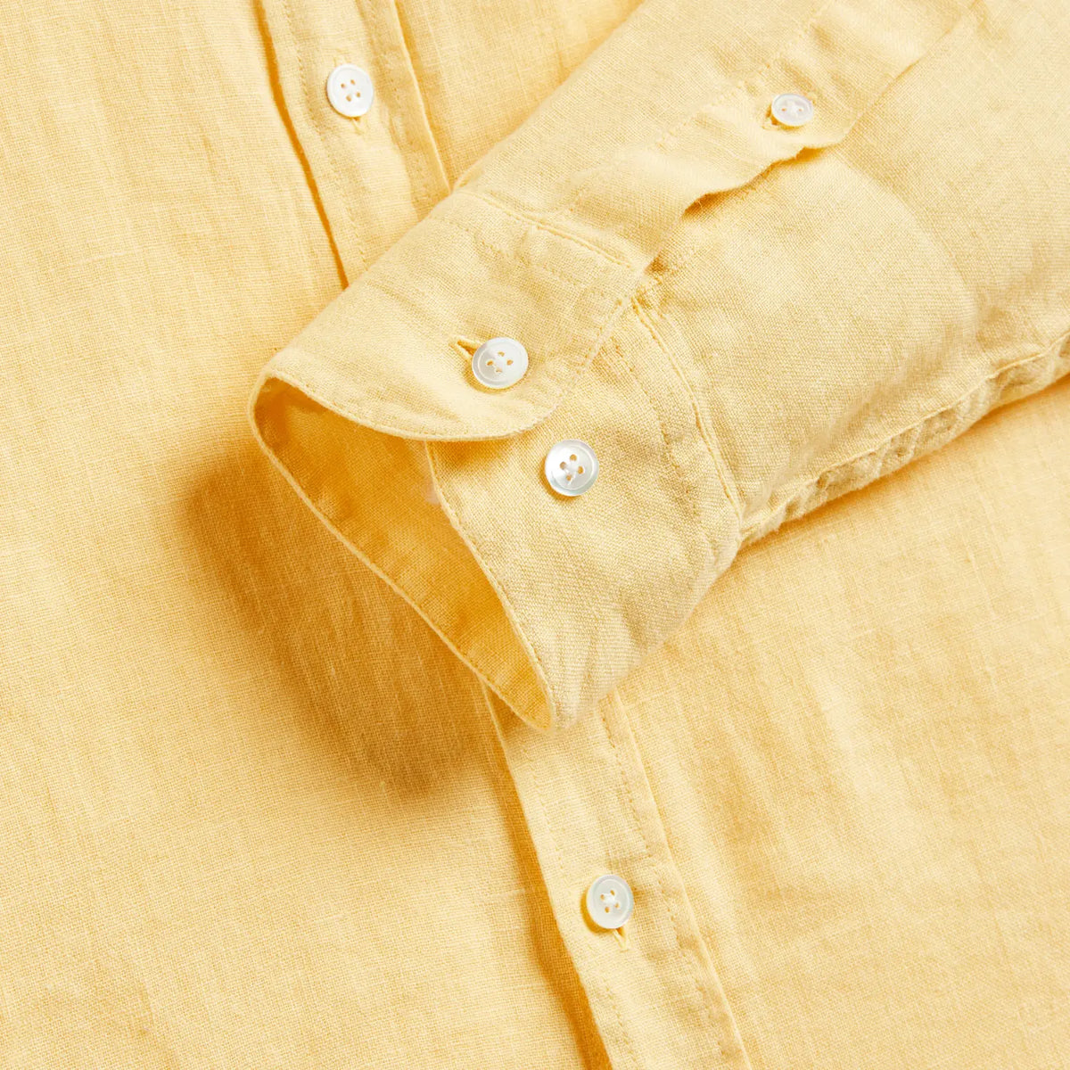Poignet à deux boutons de la Chemise Lin jaune, patte capucin et trame de lin en gros plan