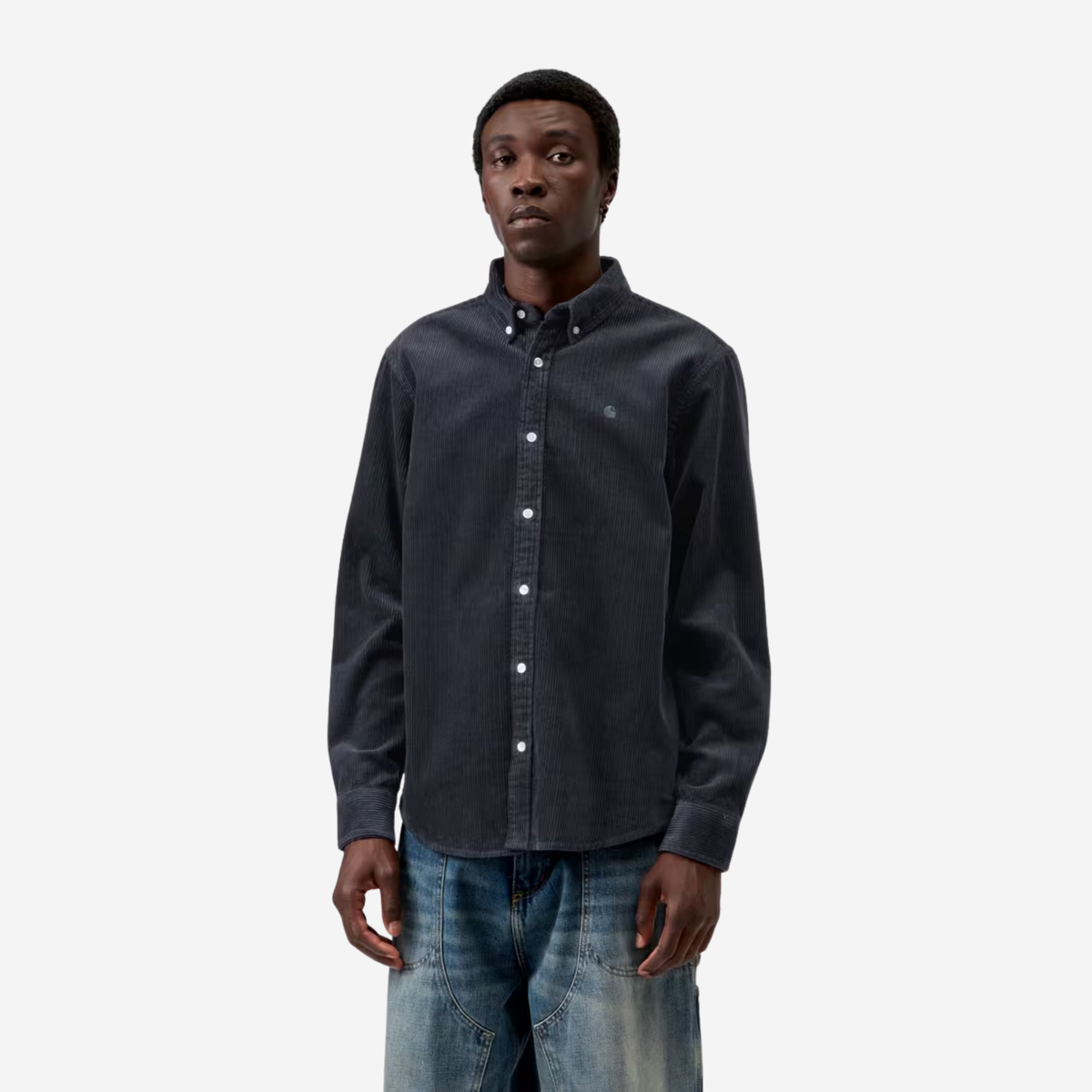 Chemise Madison Carhartt WIP en velours côtelé bleu marine portée de face, boutonnée sur un jean bleu délavé