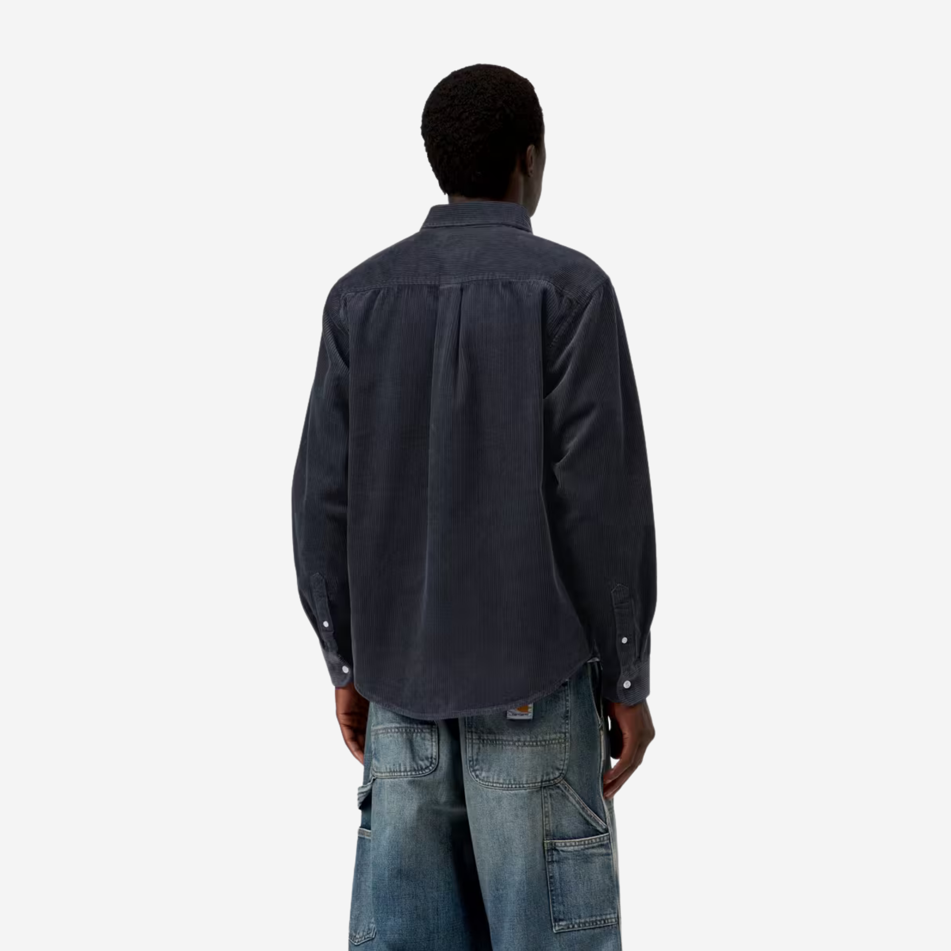 Chemise Madison Carhartt WIP en velours côtelé bleu marine portée de dos, côtes larges et bas arrondi sur un jean charpentier