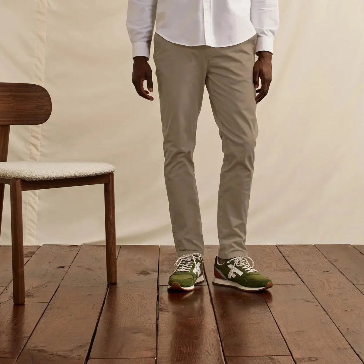 Chino Brix beige porté de face, coupe droite tombant sur des baskets vertes