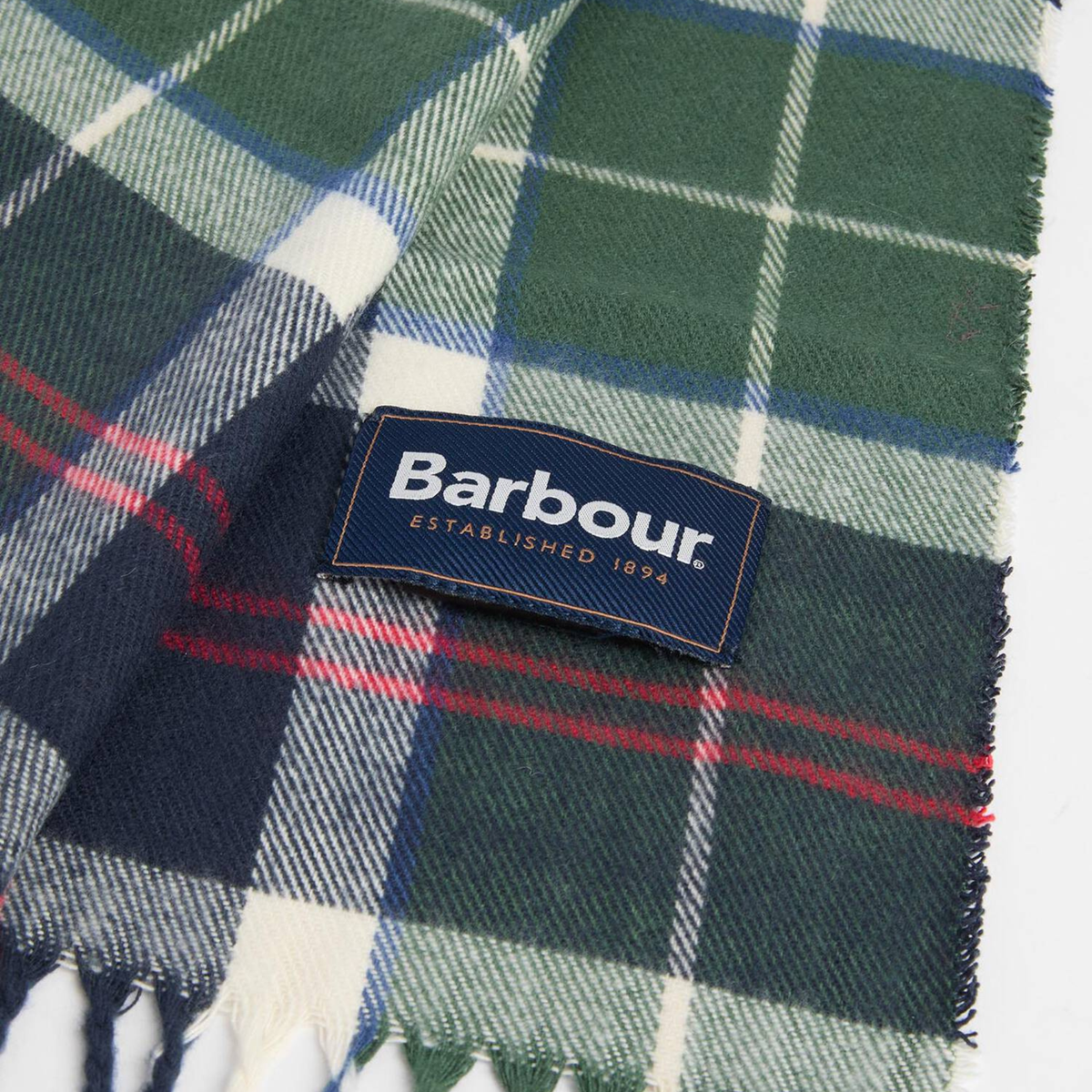 Détail de l'étiquette Barbour cousue sur l'écharpe Galingale en tartan Evergreen