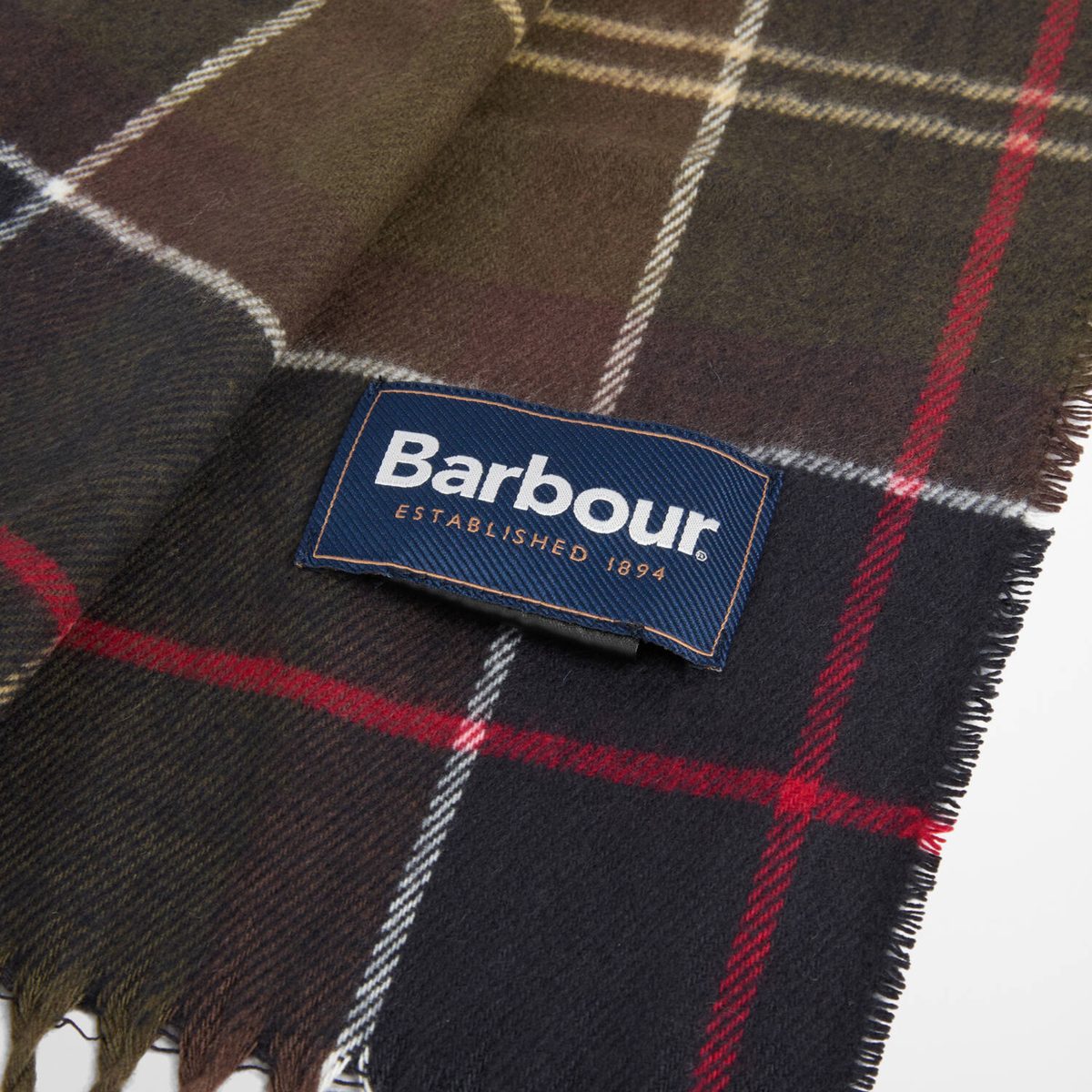 Détail de l'étiquette Barbour cousue sur l'écharpe Galingale en Classic Tartan