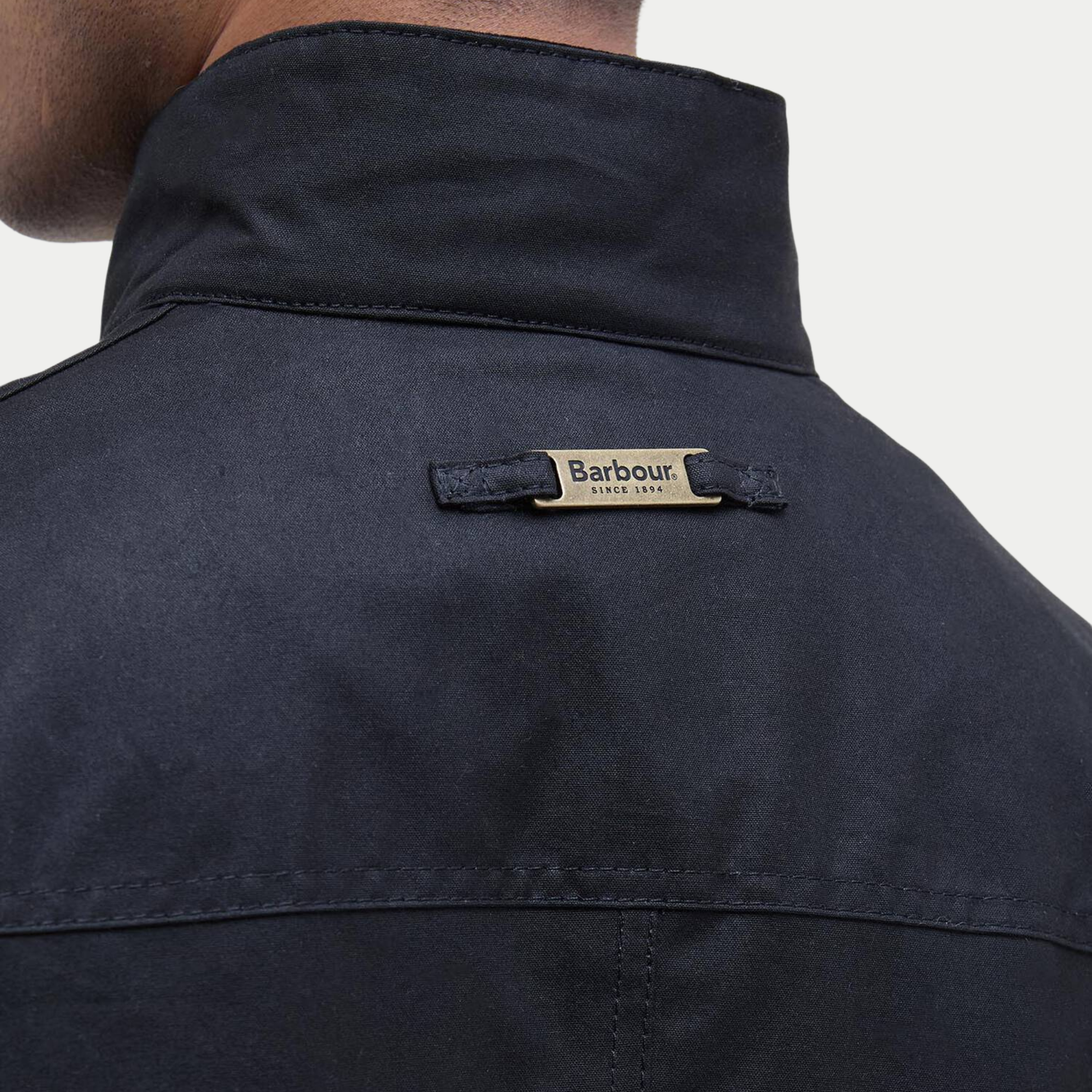 Dos du col de la veste Ogston Barbour marine : plaque métal Barbour Since 1894 sur la toile cirée