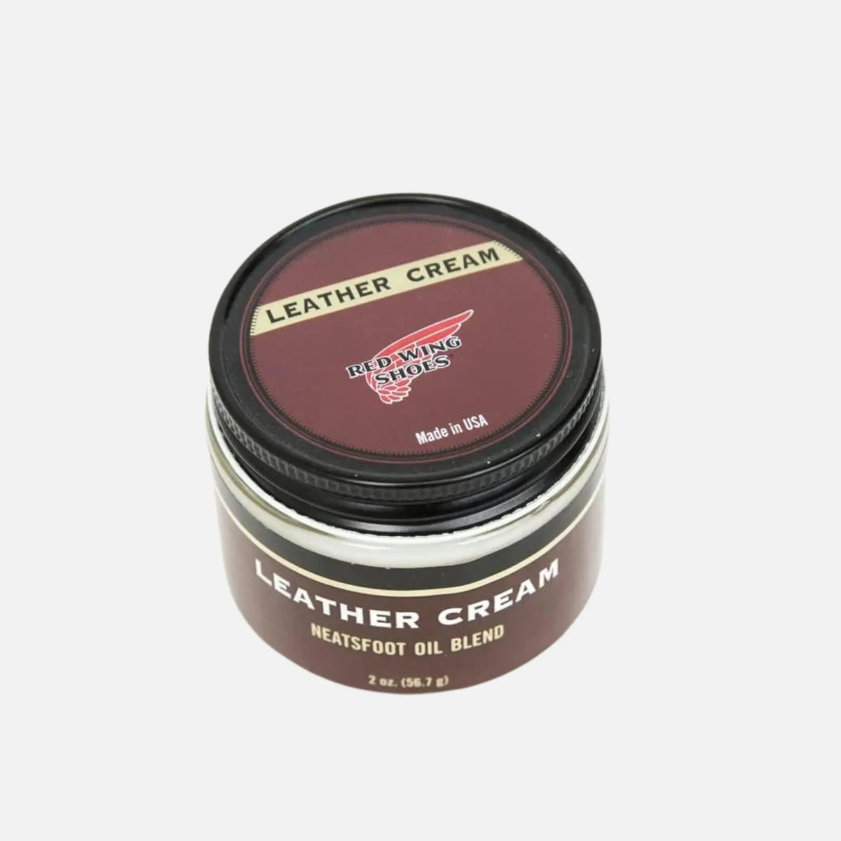 Pot en verre de crème pour cuir Red Wing Shoes, couvercle métal noir et étiquette bordeaux, vue de dessus