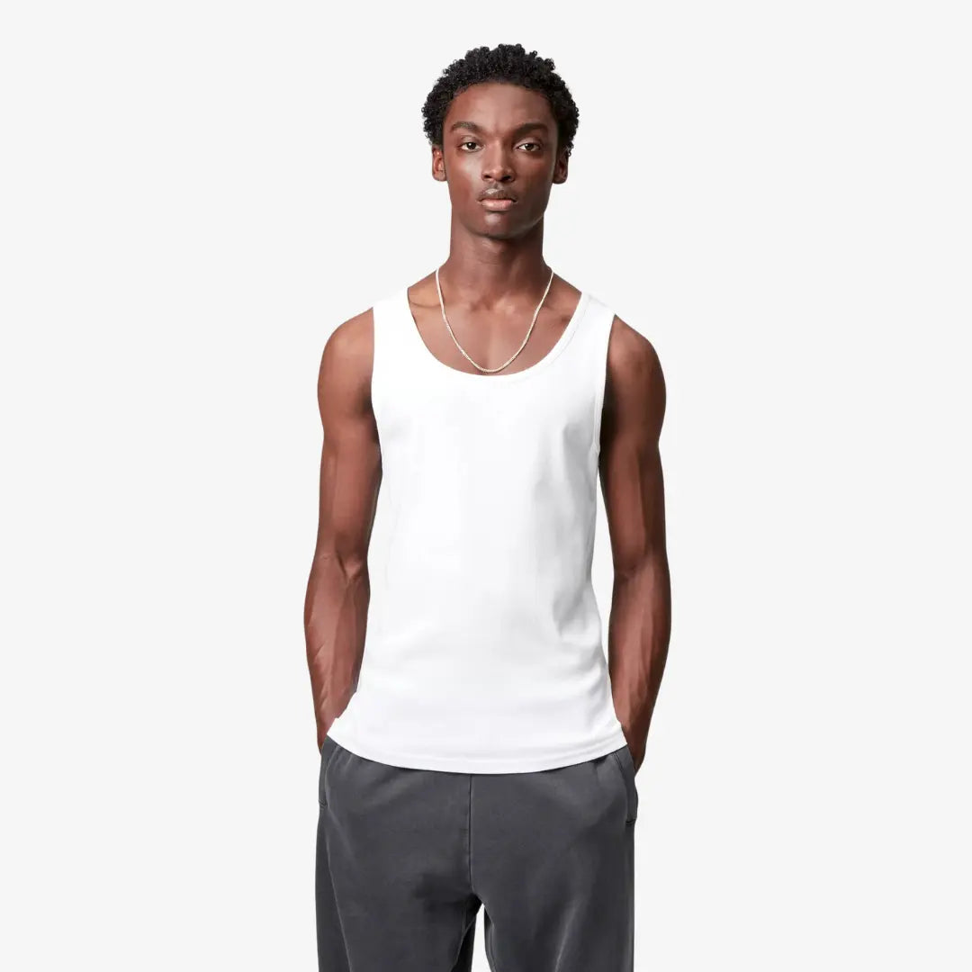 Débardeur A-shirt blanc porté de face, côtes verticales lisibles et encolure creusée sur les épaules