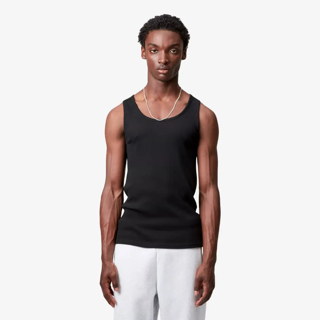 Débardeur A-shirt noir porté de face, côtes fines en relief et encolure en U dégagée sur les épaules