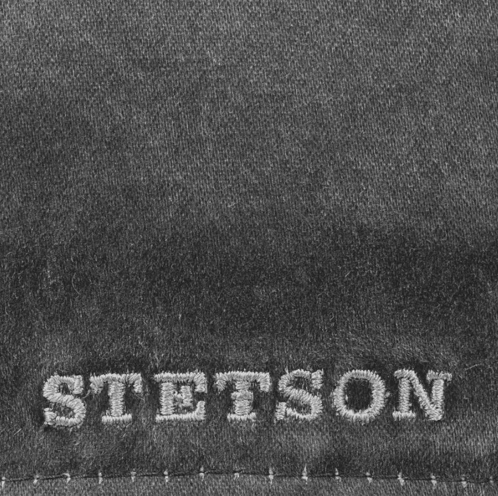 Gros plan de la broderie Stetson grise sur la toile délavée noire