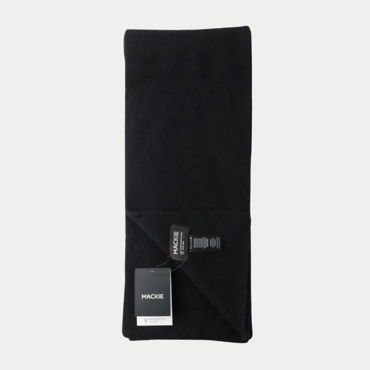 Écharpe Caolas noir profond en laine feutrée, pliée en deux, coin rabattu, étiquette tissée visible.